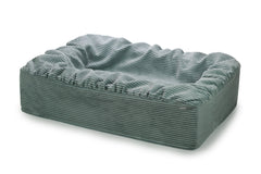 Rechteckiges hundefreundliches Bett mit weichem grauem Cordbezug und abgerundeten Kanten für optimalen Komfort.