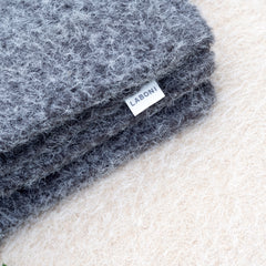 Graue Reisedecke FELTRO aus flauschigem Material mit LABONI-Etikett auf neutralem Hintergrund.