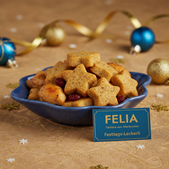 FELIA Festtags-Leckerli in Sternform für Katzen, dekoriert mit getrockneten Früchten auf festlichem Tisch.