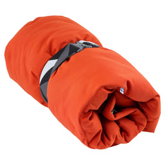 Orangefarbener Hunde-Schlafsack, zusammengerollt und mit schwarz-weiß gemustertem Gurt gesichert. Ideal für Camping mit Hund.