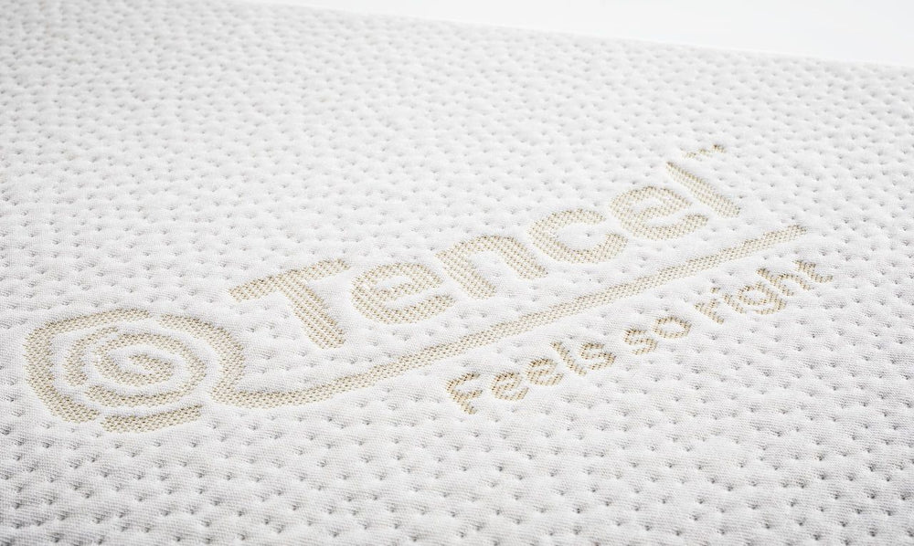 Weißes ORTHO Hundebett UNO mit strukturierter Oberfläche und goldener „Tencel™“-Aufschrift auf hellem Hintergrund.