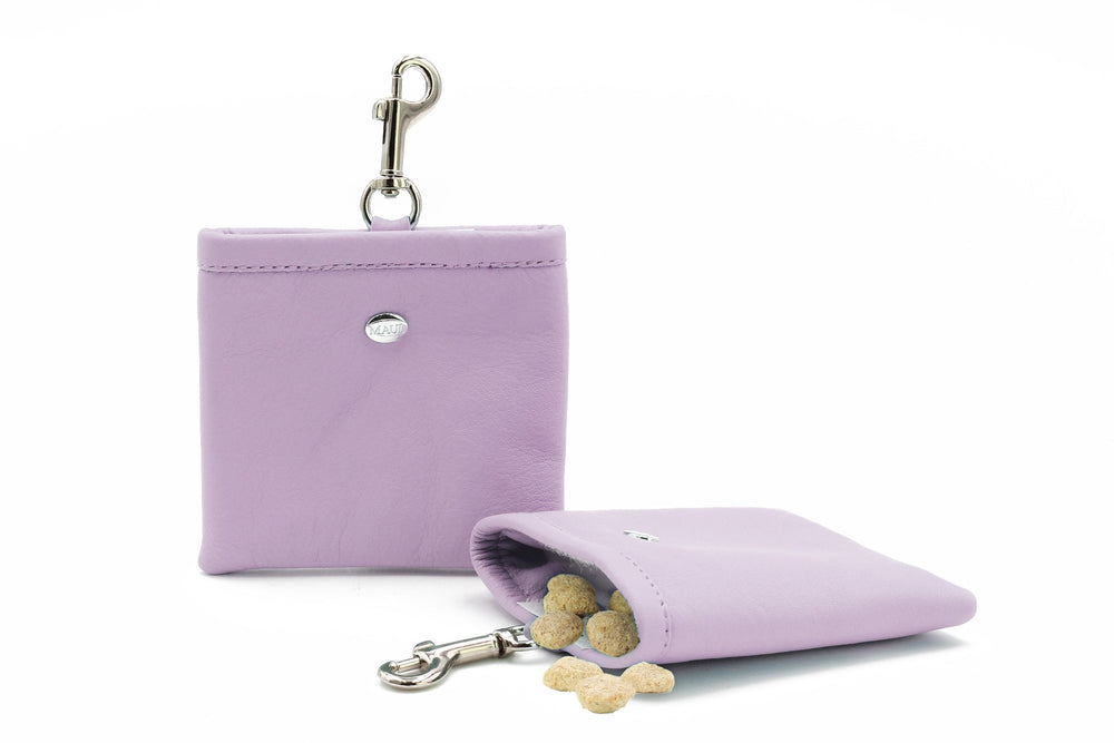 "Lilafarbene Leder-Geldbörse mit Karabinerhaken, offen mit kleinen runden Leckerlis und elegantem Design."