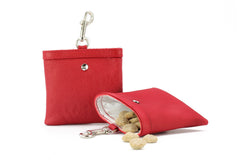 Rote Leder-Schlüsselanhänger mit Snacks, einer geöffnet, der andere geschlossen, mit metallischem Karabiner und durchsichtiger Innenauskleidung.