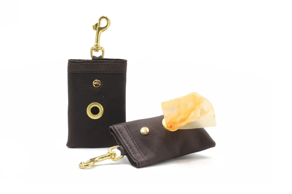 Braune Hundekotbeutel-Taschen mit goldenen Karabinern und Druckknöpfen, eine Tasche zeigt einen herausnehmbaren Kotbeutel.