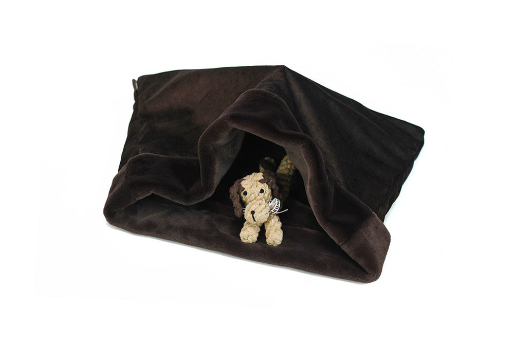 Gemütlicher Hunde-Schlafsack in Dunkelbraun mit einem süßen Hundestofftier darunter. Ideal für entspannte Momente.