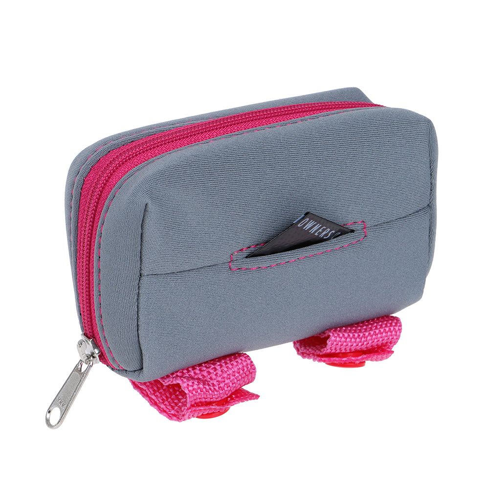 Graue DOOG Kotbeutel-Tasche mit pinken Reißverschlüssen und Klettergurten für praktische Hundebedarf unterwegs.