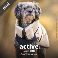Kleiner Hund in neutralem Wärme-Cape in natürlicher Umgebung, perfekt für kühle Tage und optimale Bewegungsfreiheit.