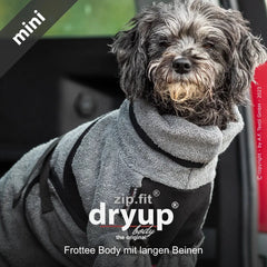 Hund im grauen Frottee-Overall mit schwarzen Details, sitzt im Fahrzeug und wirkt dabei gemütlich und komfortabel.