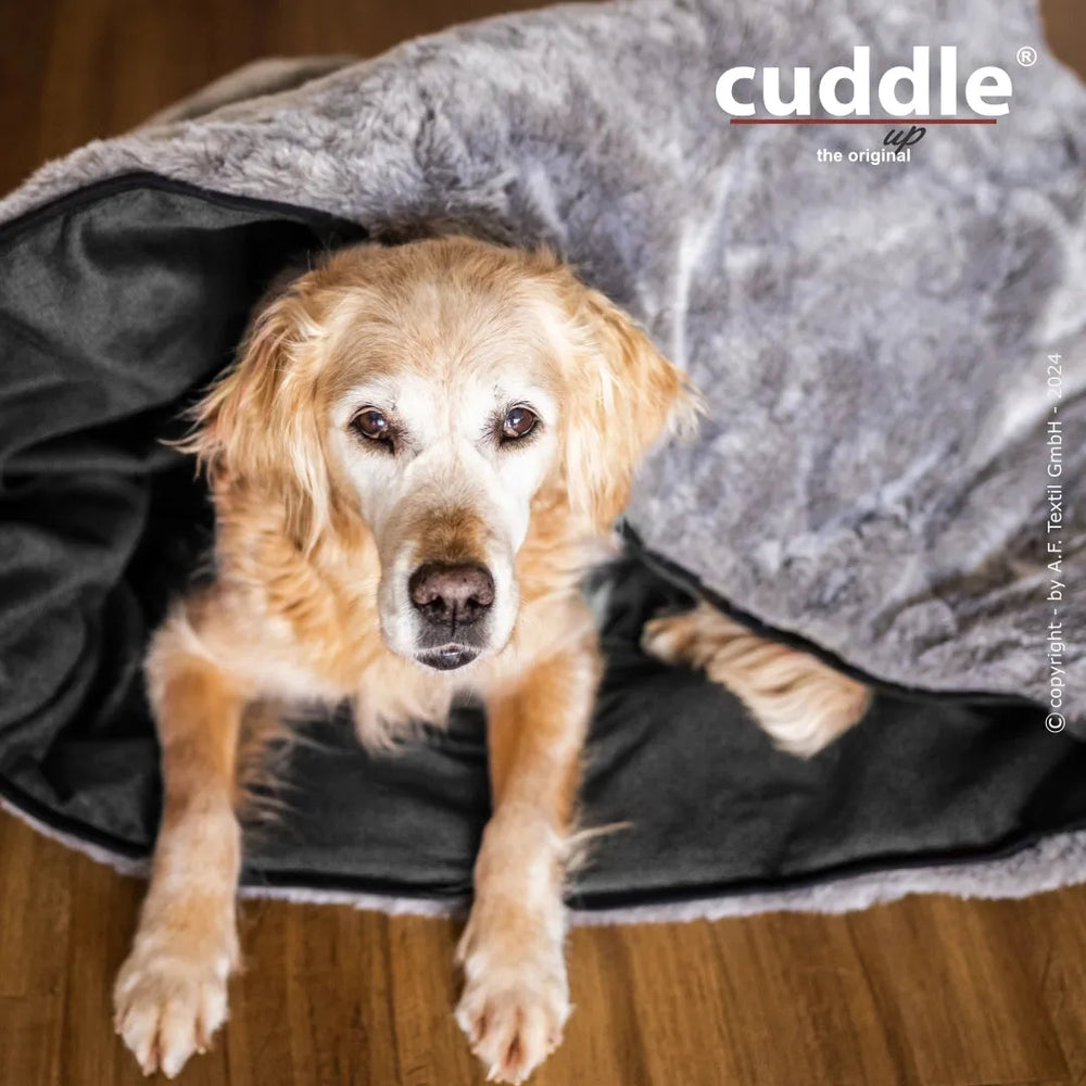 Entspannter Hund liegt in weichem grauen Kuscheltuch von cuddle.up® für ultimativen Komfort und Wärme.