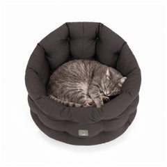 Graues, rundes Katzenbett mit weicher Polsterung, in dem eine graue Katze entspannend schläft.