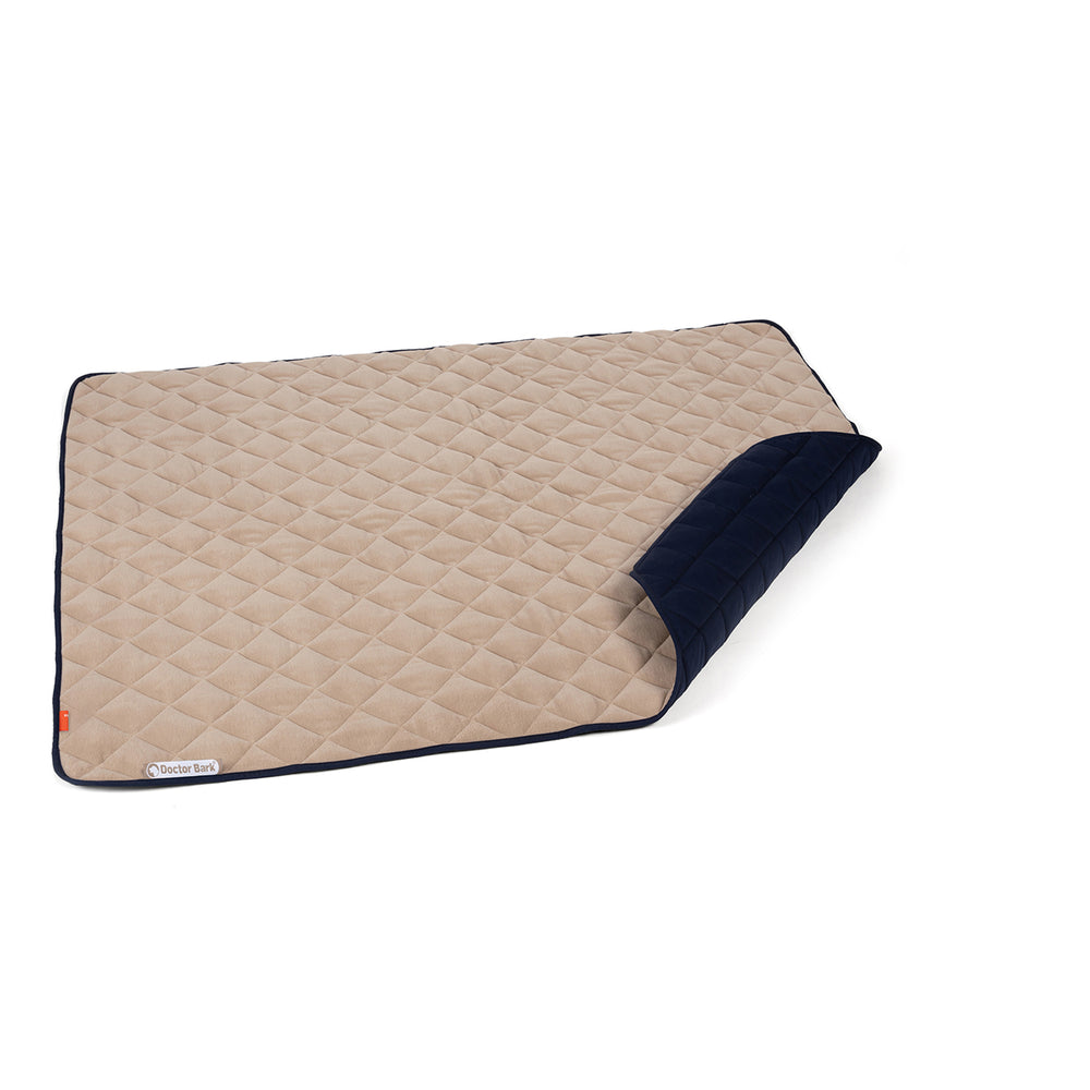 Bequeme Fleece-Steppdecke in Beige und Dunkelblau, mit gestepptem Muster und sorgfältig genähten Kanten.