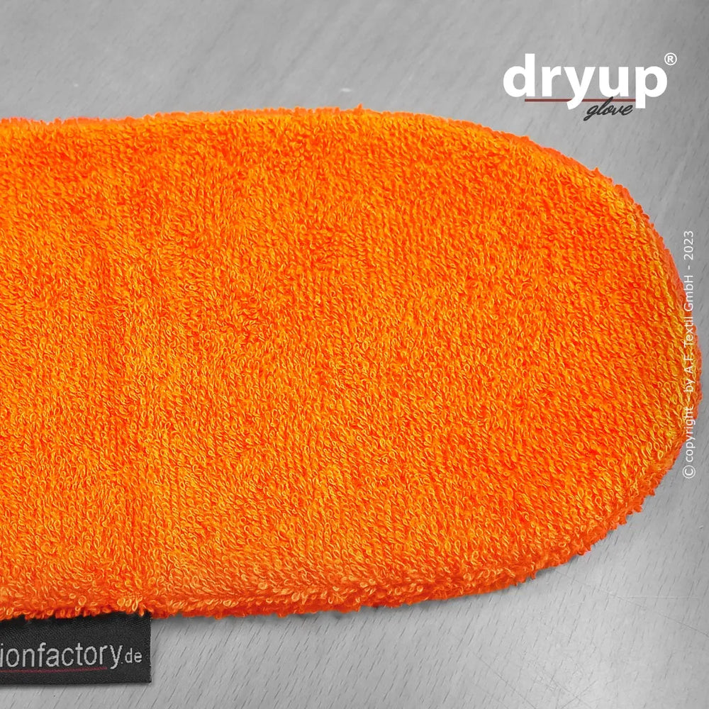 Oranger Trocknungshandschuh aus Frottee mit flauschiger Oberfläche auf heller Unterlage. Ideal zum schnellen Trocknen.