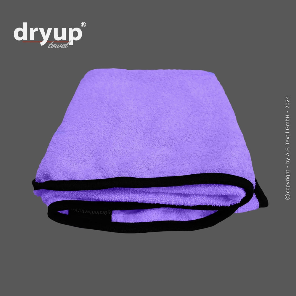 Lila Dryup® Handtuch mit schwarzem Rand, weich und flauschig, gefaltet präsentiert das Logo „dryup“.