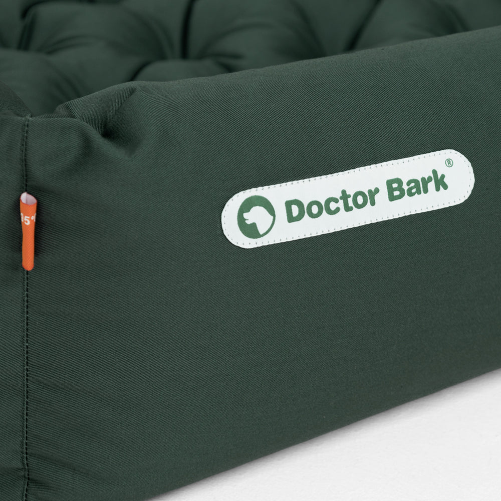 Orthopädisches Hundebett von Doctor Bark in Dunkelgrün mit weicher, gepolsterter Oberfläche und quadratischer Form.