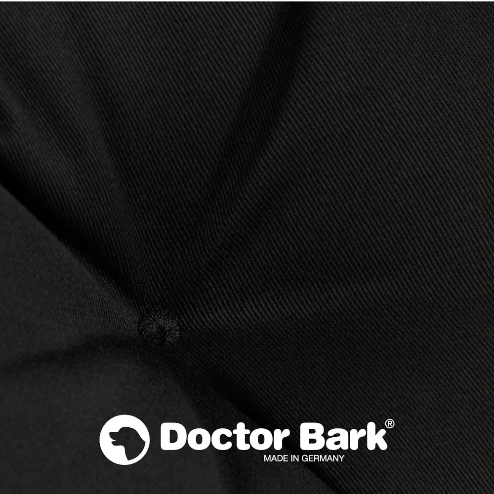 Nahaufnahme des schwarzen Doctor Bark Hundebetts mit markantem Logo und weich eingezogenem Stoff.