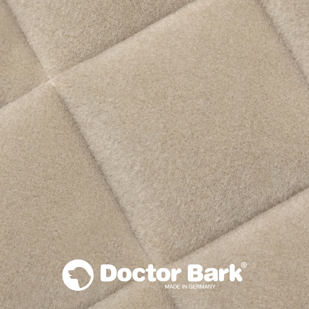 Beige Fleece Steppdecke mit quadratischer Polsterung und Doctor Bark Logo, hergestellt in Deutschland.