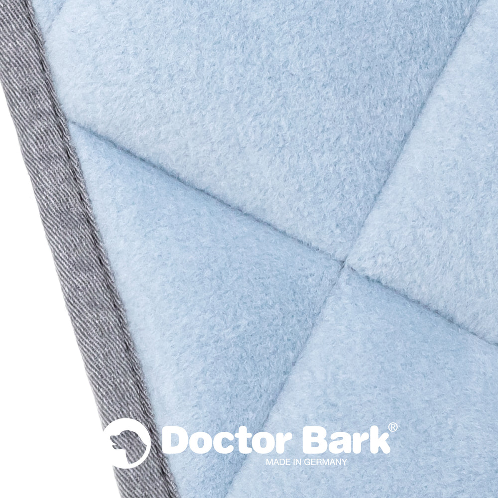 "Bequeme blaue Fleece Steppdecke mit grauer Kante und Doctor Bark-Logo für höchsten Komfort."