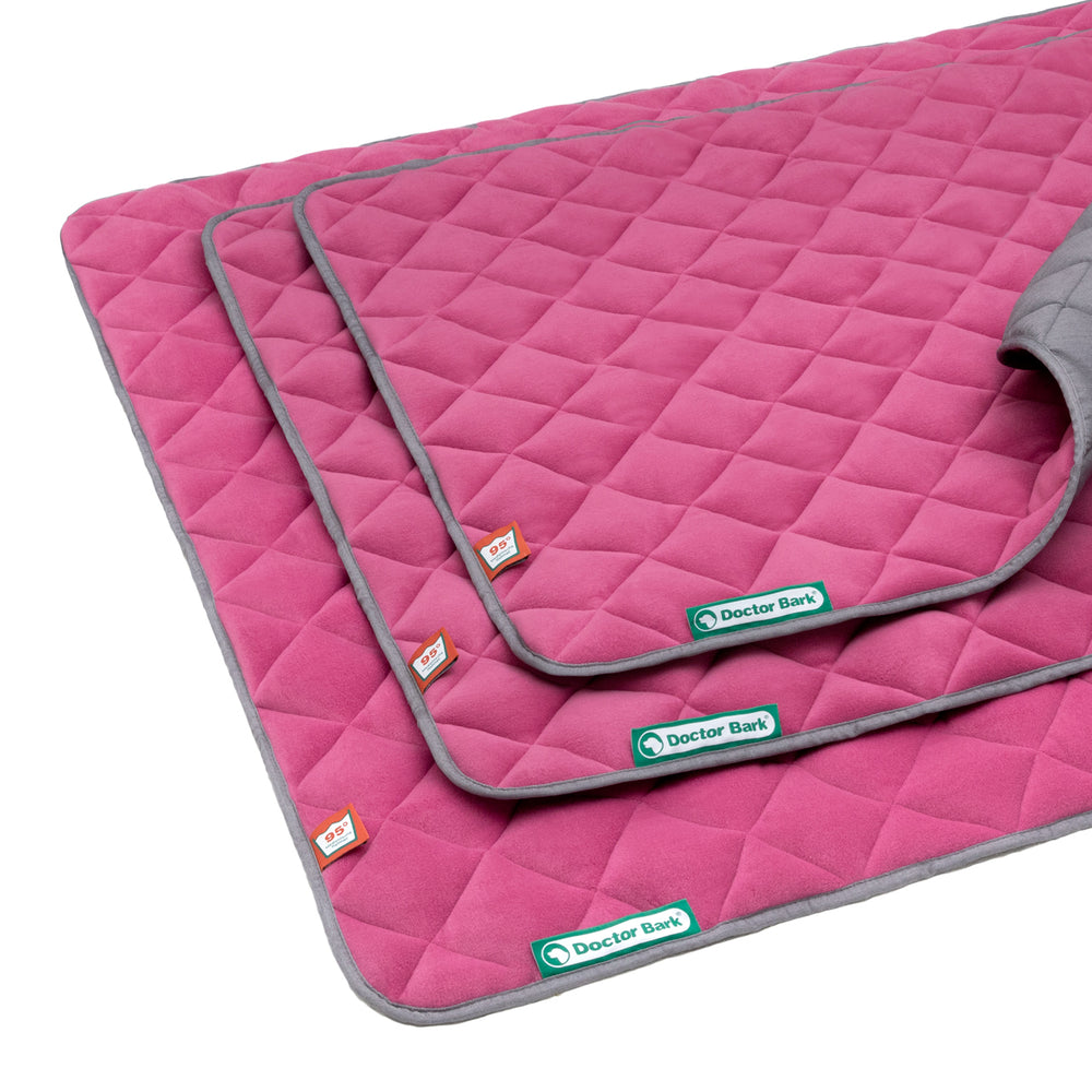 Drei Hundematten in Pink mit grauer Umrandung und gestepptem Design, ideal für stilvolle Haustierinterieurs.