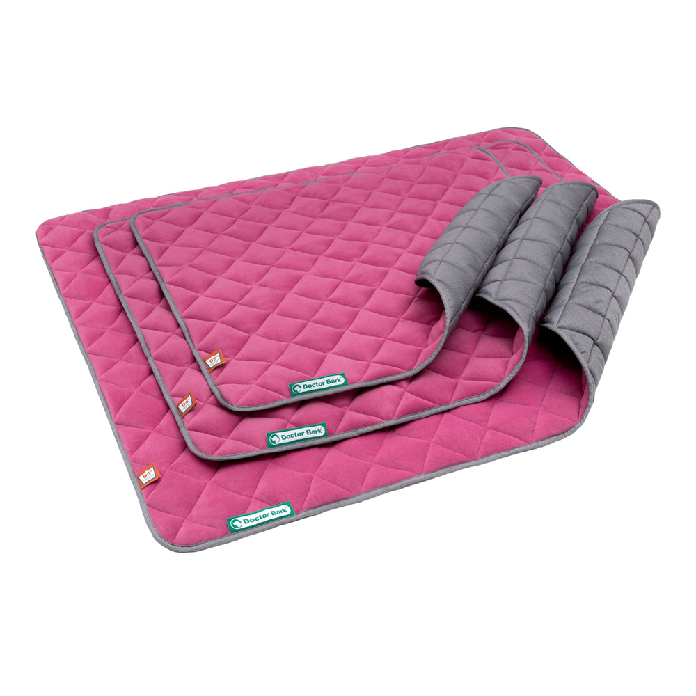 Bunte Fleece Steppdecke mit rautenförmigem Muster in Pink und grauer Unterseite, ideal für Gemütlichkeit und Komfort.