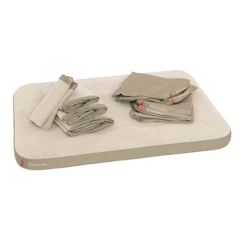 Elegante, rechteckige Ortho-Matratze mit abgerundetem Rand in neutralem Farbton neben gefalteten, beigen Bettlaken.