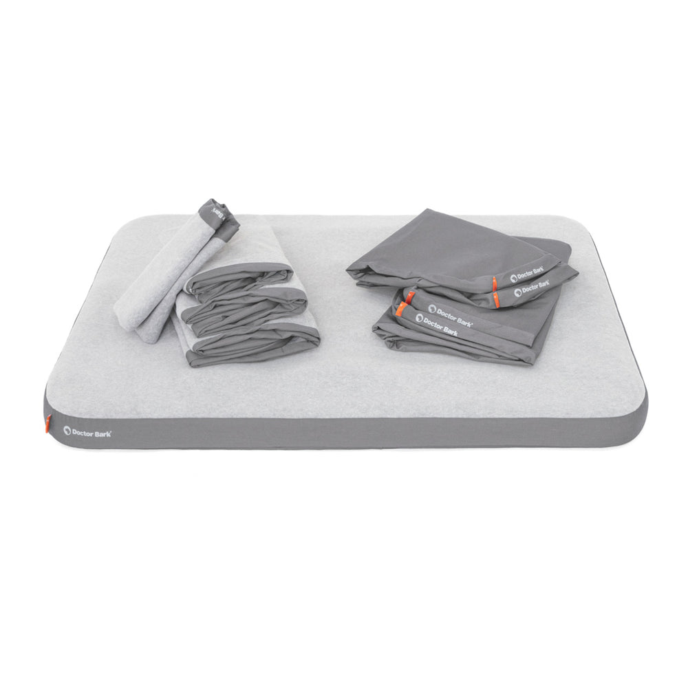 Graue Doctor Bark Fleece Matte mit hellgrauen Falt-Bettwäsche-Sets in ordentlicher Anordnung.