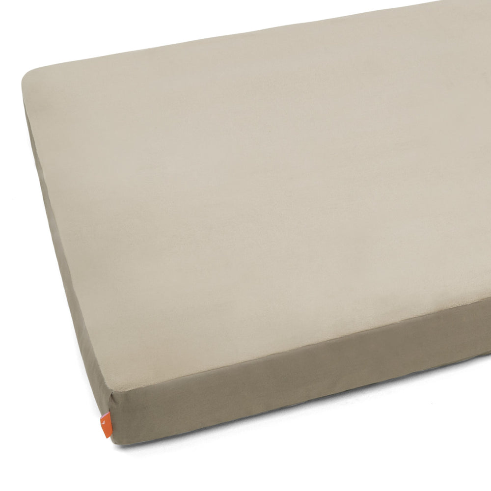 Beige orthopädische Matratze mit abgerundeten Ecken und orangefarbenem Etikett. Ideal für einen erholsamen Schlaf.
