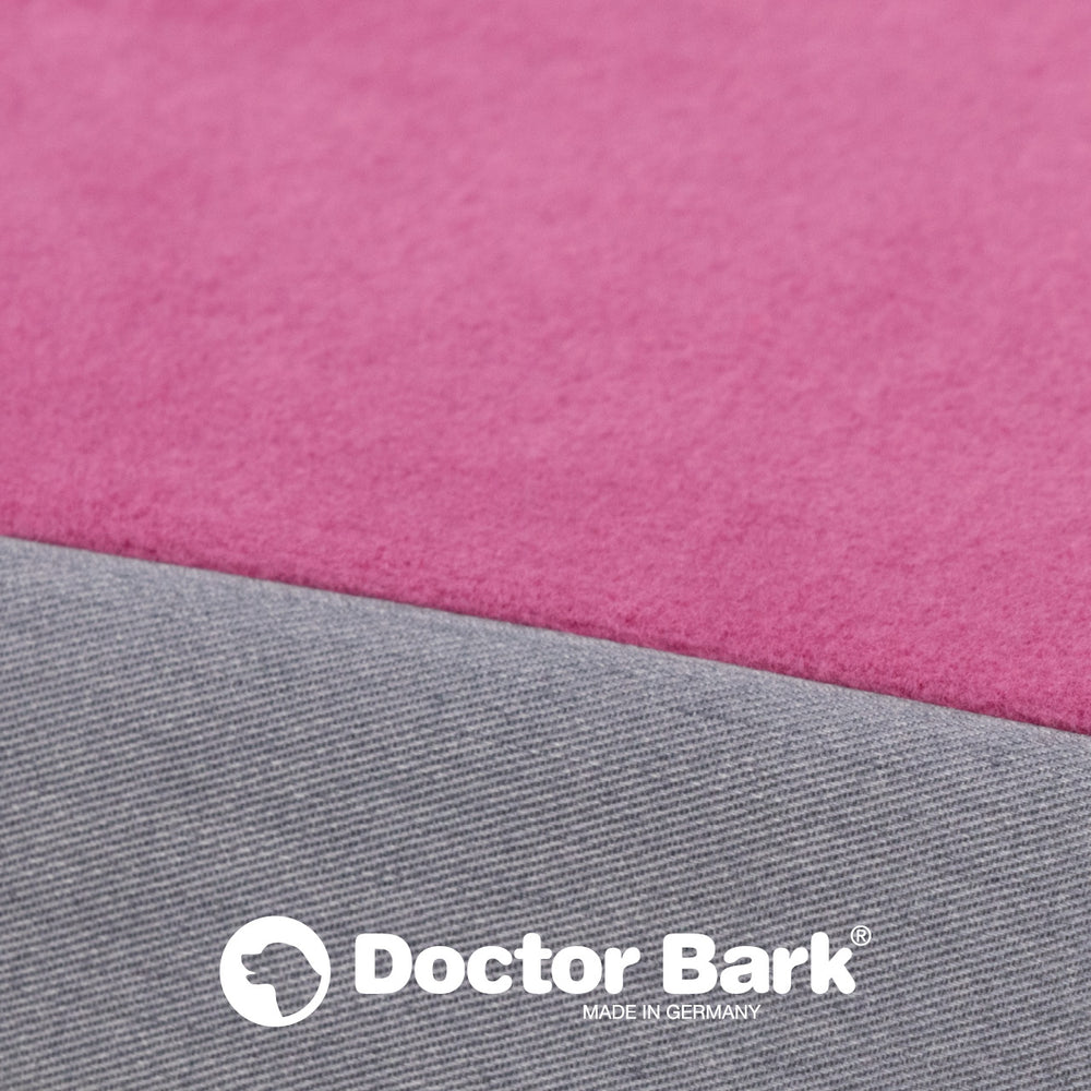 Nahansicht von pinker und grauer Stofflage der Doctor Bark orthopädischen Matratze mit deutschem Logo.