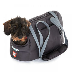 Graue Hundetasche mit abnehmbarem Schulterriemen und einem kleinen Hund, der neugierig aus der Öffnung schaut.