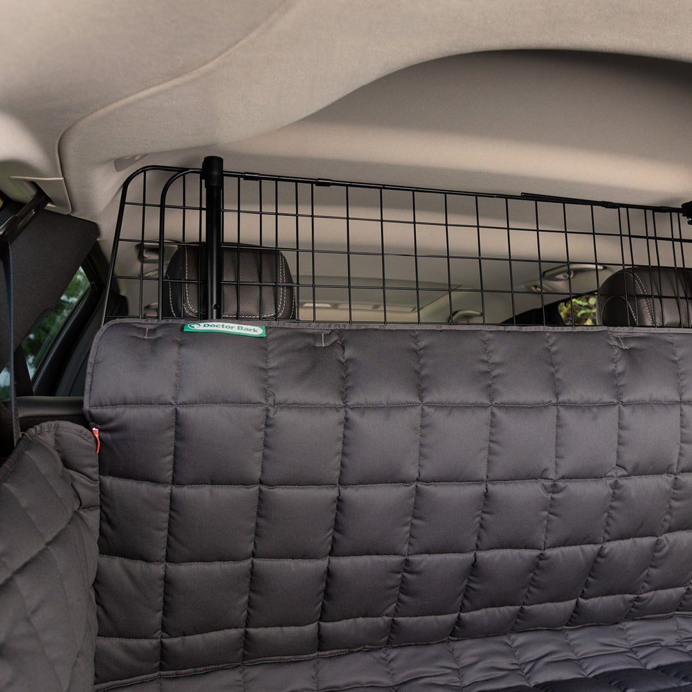 Schwarzes Kofferraumgitter und gepolsterte Rückbankabdeckung im Fahrzeug, für sicheren Transport.