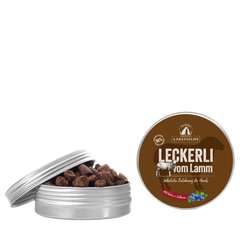 "Metall-Dose mit Hundeleckerlis vom Lamm der Marke Lakefields, teilweise geöffnet vor schwarzem Hintergrund."