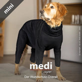 Hund in stylischem schwarzen Overall mit hohem Kragen, umgeben von heller Wohnumgebung.