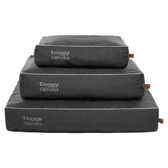 Stapel von drei grauen Hundebetten mit weißen Kanten und „Doggy Siesta“-Branding in verschiedenen Größen.
