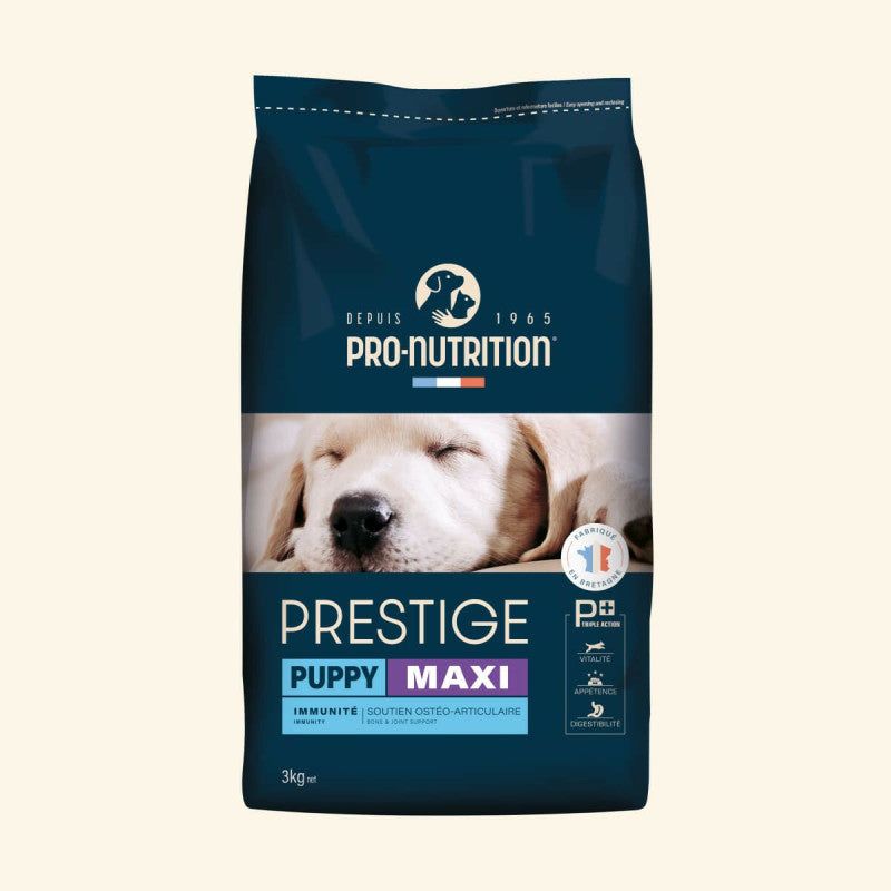 Blauer Sack mit 3 kg Prestige Puppy MAXI Hundefutter von Pro-Nutrition, im Hintergrund ein schlafender Hund.