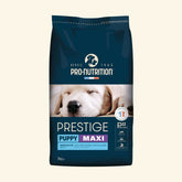 Blauer Sack mit 3 kg Prestige Puppy MAXI Hundefutter von Pro-Nutrition, im Hintergrund ein schlafender Hund.