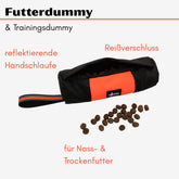 Futterdummy in Schwarz und Orange mit reflektierender Handschlaufe, ideal für Futterspiele und Trainings mit Hunden.