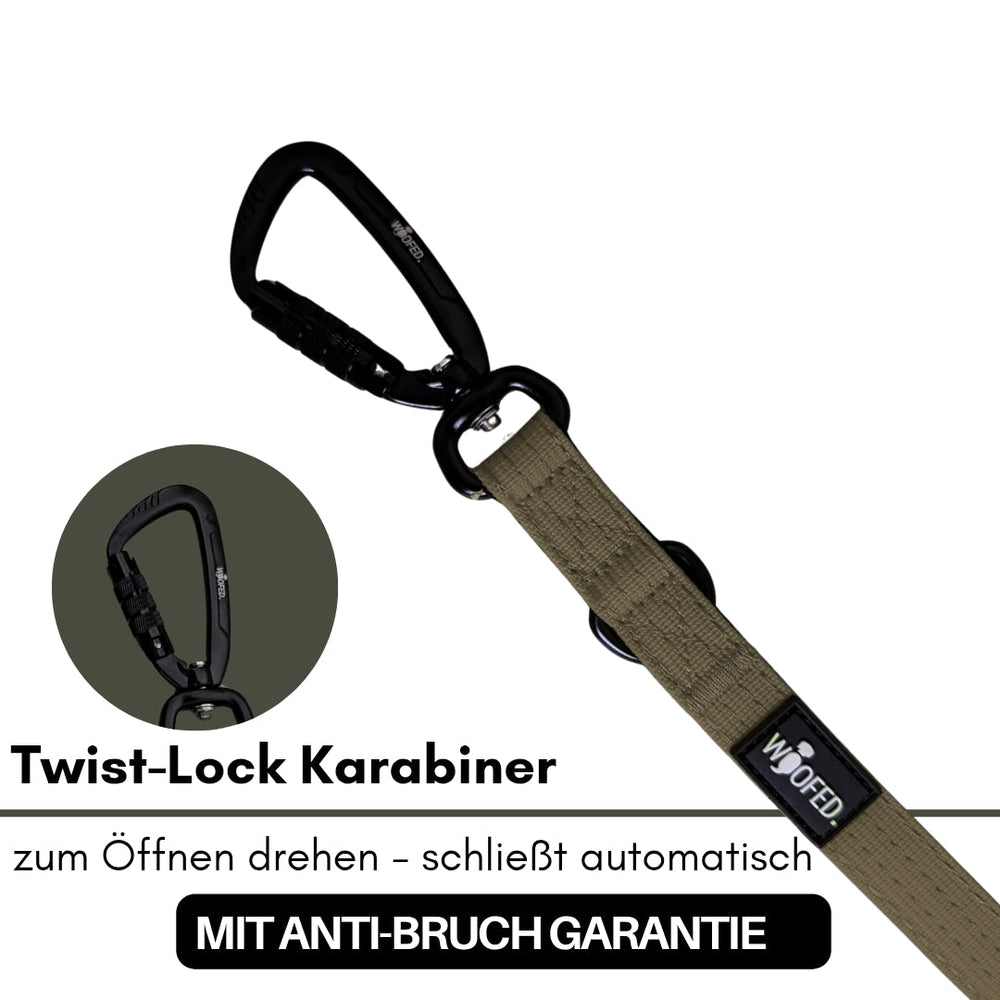 Schwarzer Twist-Lock Karabiner mit khaki-farbenem Band und Anti-Bruch Garantie für optimale Sicherheit bei der Verwendung.
