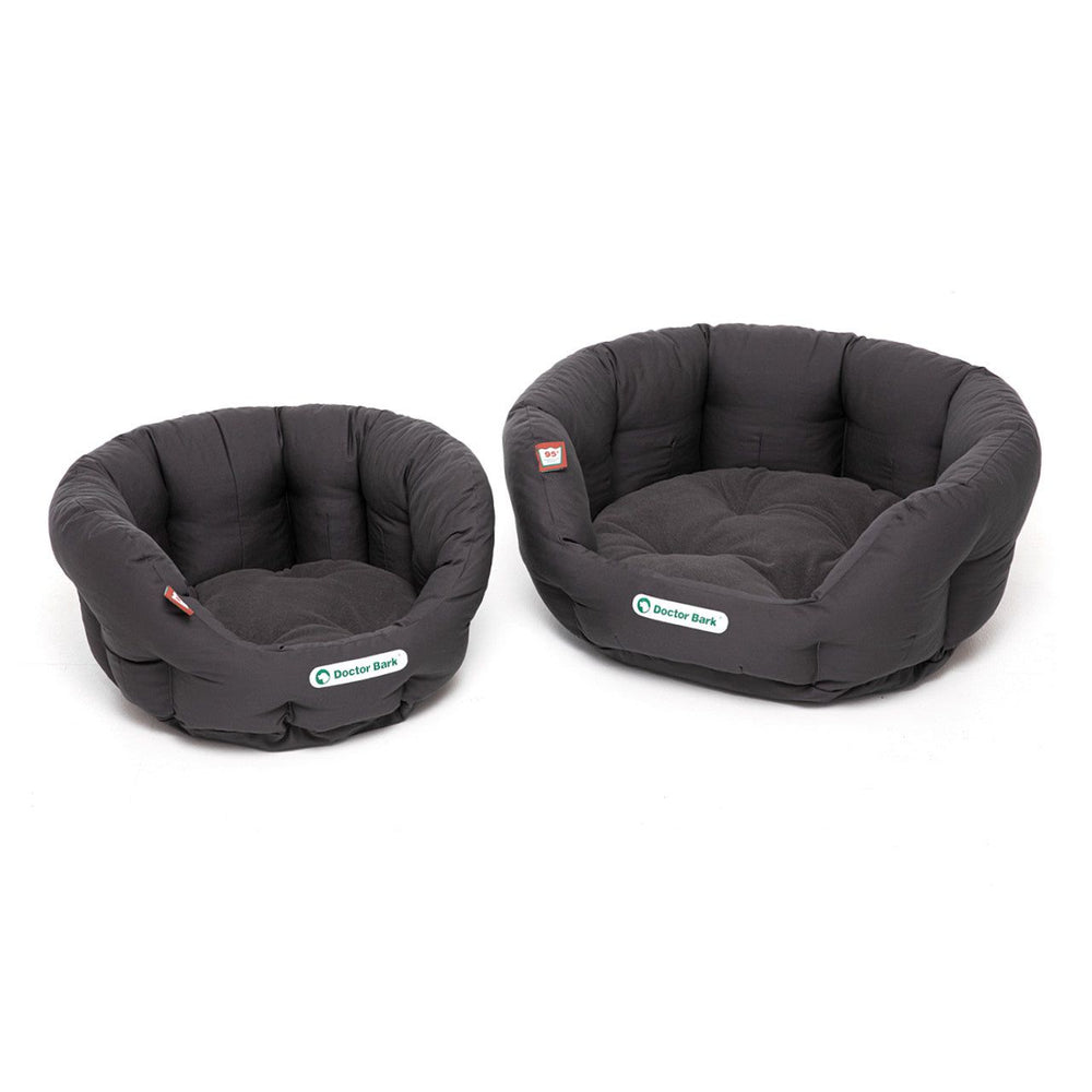 Zwei runde, schwarze, gepolsterte Hundebetten in verschiedenen Größen mit weicher Oberfläche.