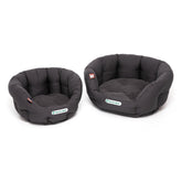 Zwei runde, schwarze, gepolsterte Hundebetten in verschiedenen Größen mit weicher Oberfläche.