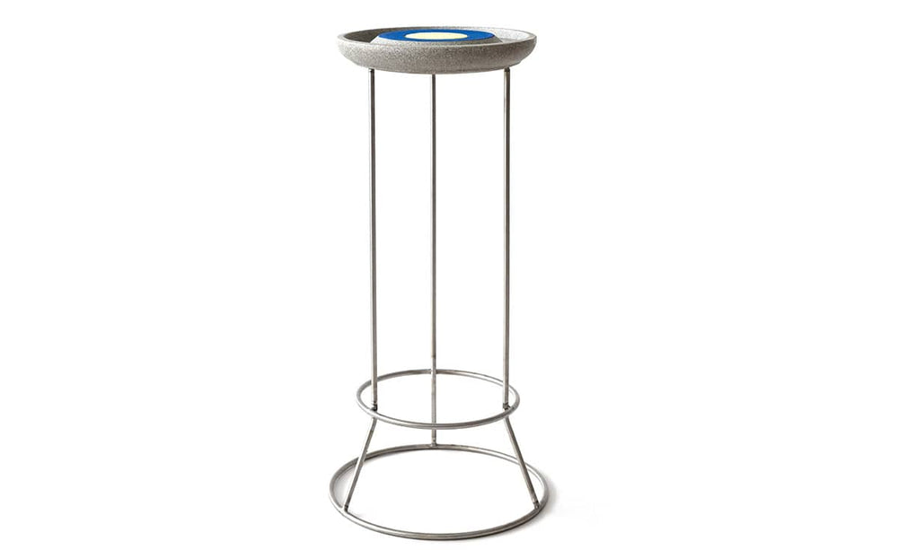 Moderner Hocker aus Beton mit blauem Design und filigranem Metallgestell, ideal für die Insektenstation.