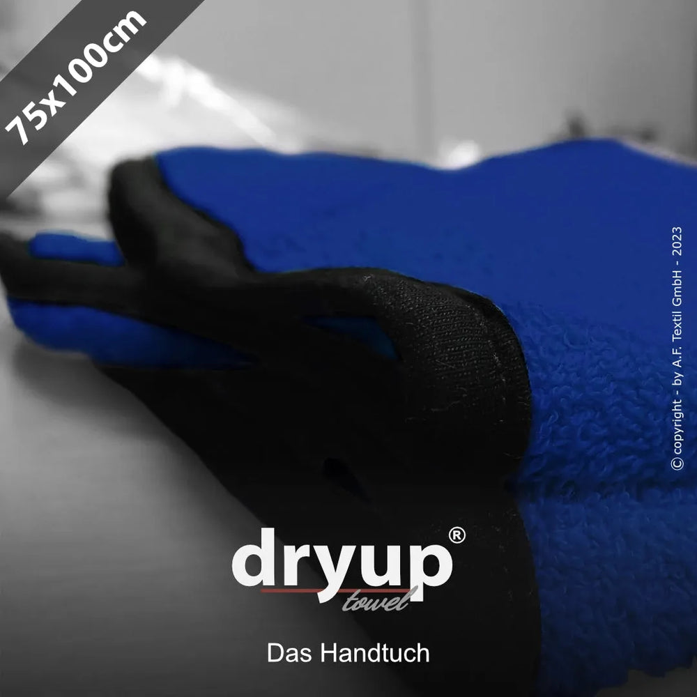 Blaues Dryup® Handtuch (75x100 cm) mit schwarzer Aufschrift auf unscharfem Hintergrund.