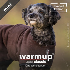 Hund im braunen, wendbaren Warmup© Cape in schöner Naturumgebung. Limited Edition für stilvolle Haustiere.