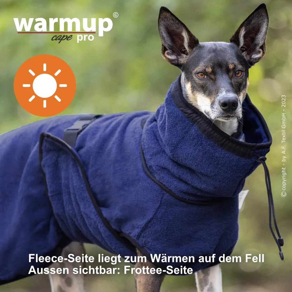 Hund trägt blauen Wende-Cape mit kuscheligem Fleece und verstellbarem Bauchgurt für zusätzliche Wärme.