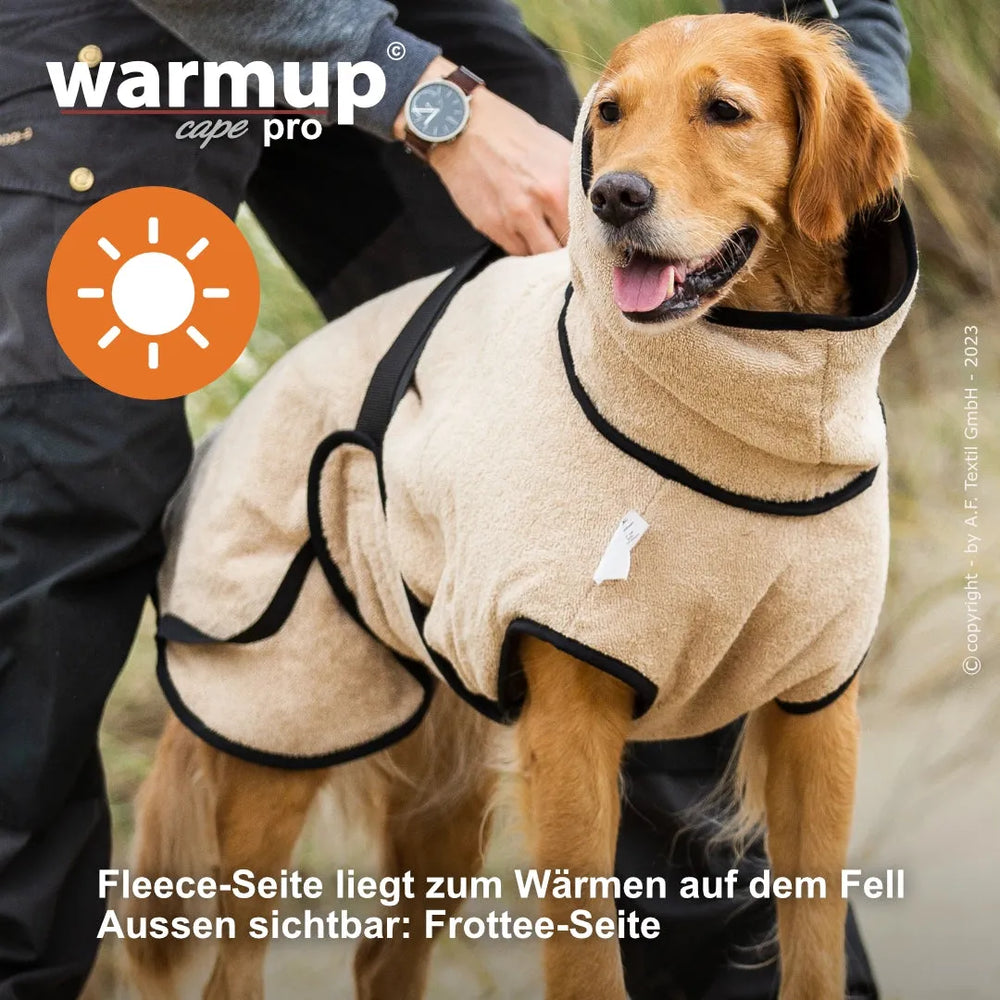 Hund im beige-farbenen Warm-Up Cape mit Fleece-Seite nach außen, komfortabel und warm, schwarze Akzente, gut angepasst.