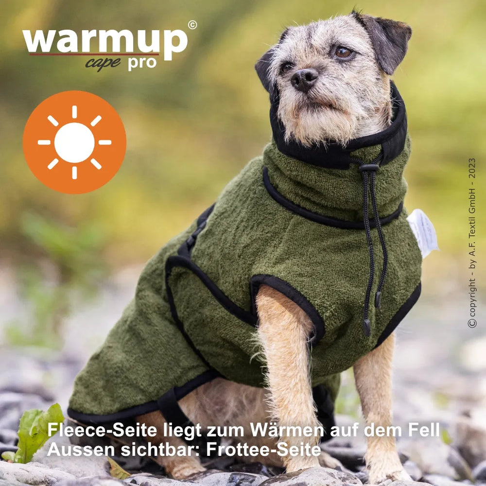 Hund im olivgrünen Wende-Cape von Warmup©, Fleece-Innenseite, ideal für kalte Tage.