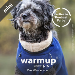 Kleiner Hund trägt Wende-Cape WARMUP© in dunkelblau mit sandfarbenem Innenfutter aus Frotté. Stylish und kuschelig!