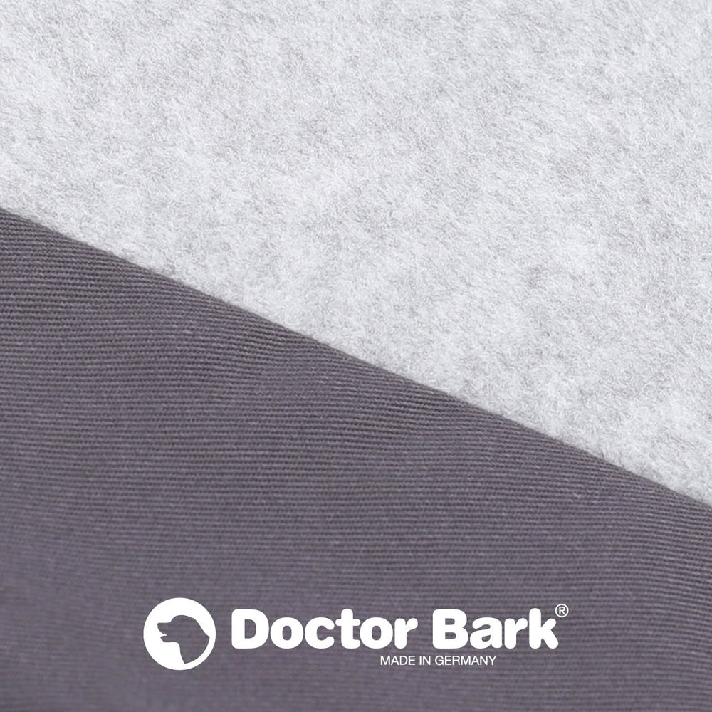 Stoffmuster der Doctor Bark orthopädischen Matratze mit grauer Filz- und glatter Textur sowie Logo im Bild.