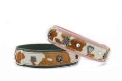 Zwei stilvolle Hundehalsbänder: grün mit Muster und rosa mit Blumen- und Herzverzierungen.