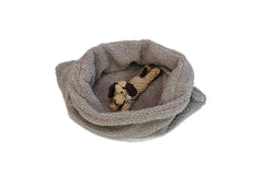 "Beiges Hunde-Schlafsack mit erhöhtem Rand und Kauspielzeug in Hundeform aus Seil."