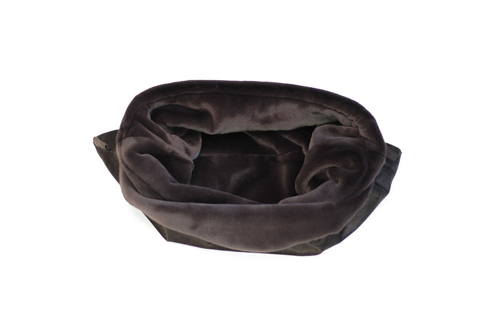 Dunkelgrauer, samtiger Hunde-Schlafsack in runder Form auf weißer Oberfläche. Ideal für gemütliche Ruhephasen.
