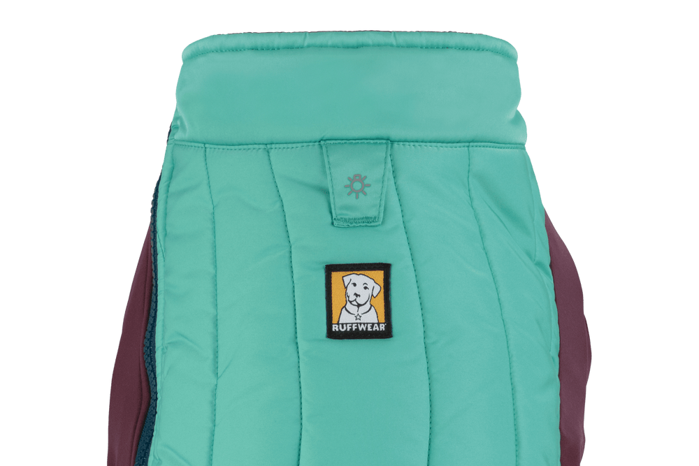 Mintgrüne Ruffwear Hundejacke Powder Hound™ mit maroonfarbenem Rücken und gelbem Logo auf der Vorderseite.